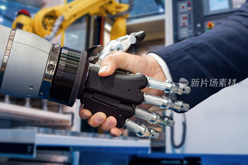 一个商人和一个机器人握手的手。