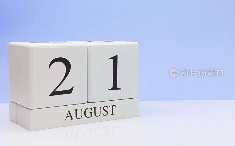 8月21日。月21日，日历在白色的桌子上反射，以浅蓝色为背景。夏天的时候，空白的文字