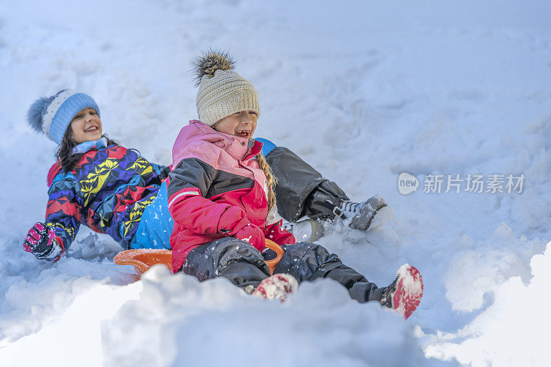 女孩们在雪地上滑行