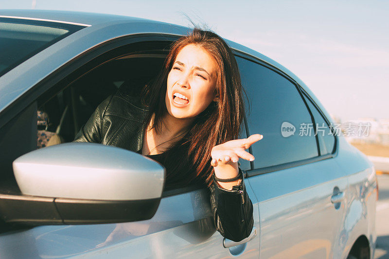 漂亮的黑发长发愤怒的年轻亚洲女人开车和尖叫在车