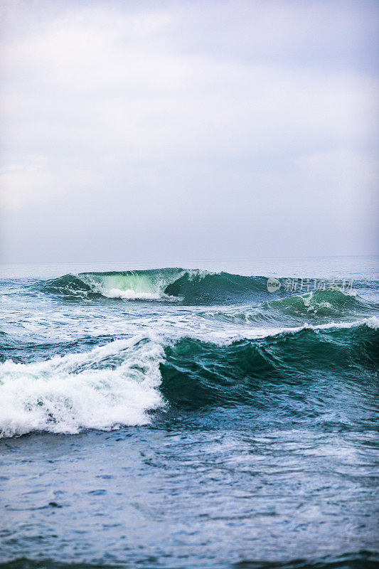 大海中蓝色的波浪。在巴厘岛破浪冲浪