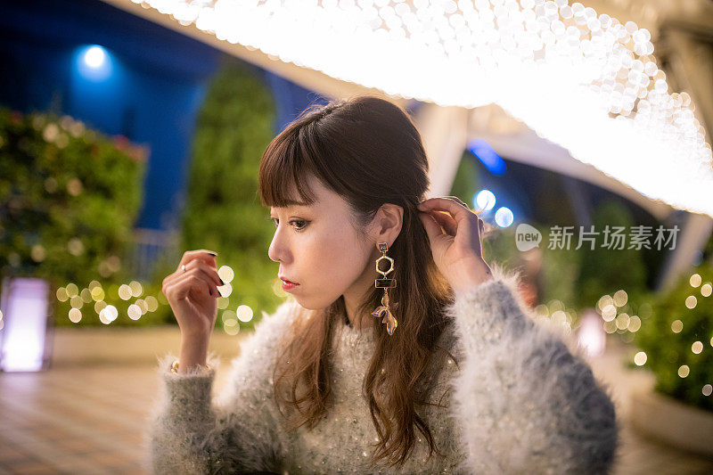 一个日本女人在圣诞彩灯下梳头发