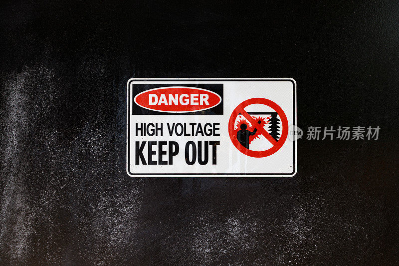 危险，高电压，黑色墙上的禁止入内标志。