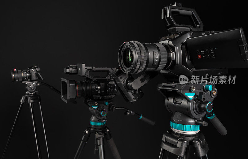 三种不同类型的视频电影摄影相机在黑色背景下，侧视图
