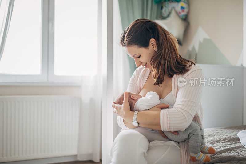 母亲在家里母乳喂养她的男婴