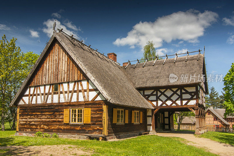 来自波兰Olsztynek的Masuria地区的带有拱廊扩建、半木墙和茅草屋顶的小屋。