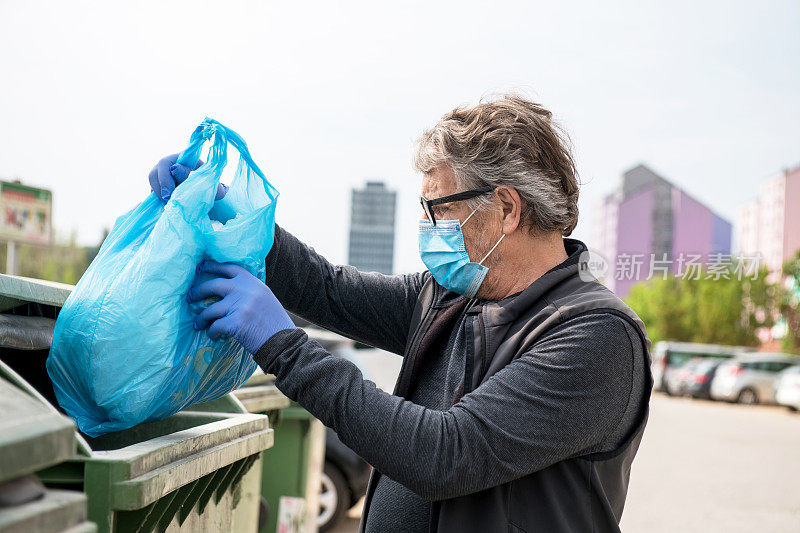 欧洲冠状病毒时代，戴口罩的老人对垃圾进行分类