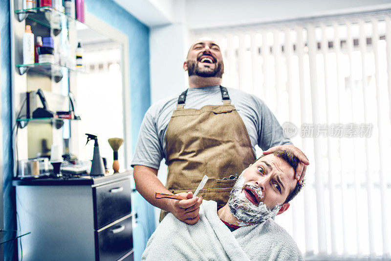 疯狂的理发师大笑，而顾客在刮胡子时害怕剃须刀