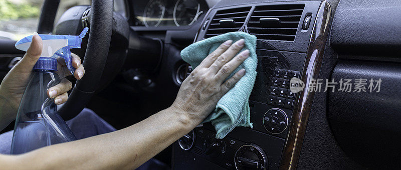 成年妇女消毒汽车仪表板与消毒湿擦