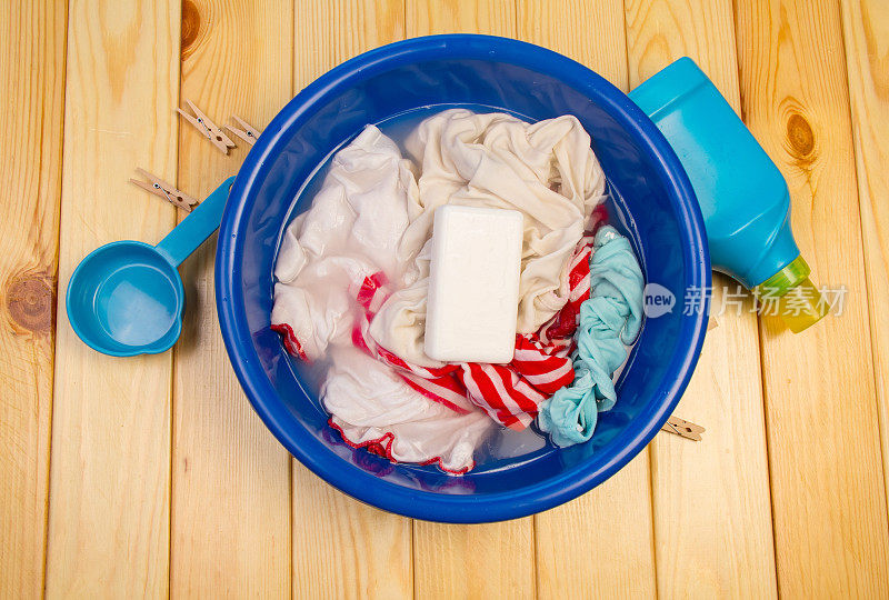 脏衣服和肥皂放在蓝色的碗里