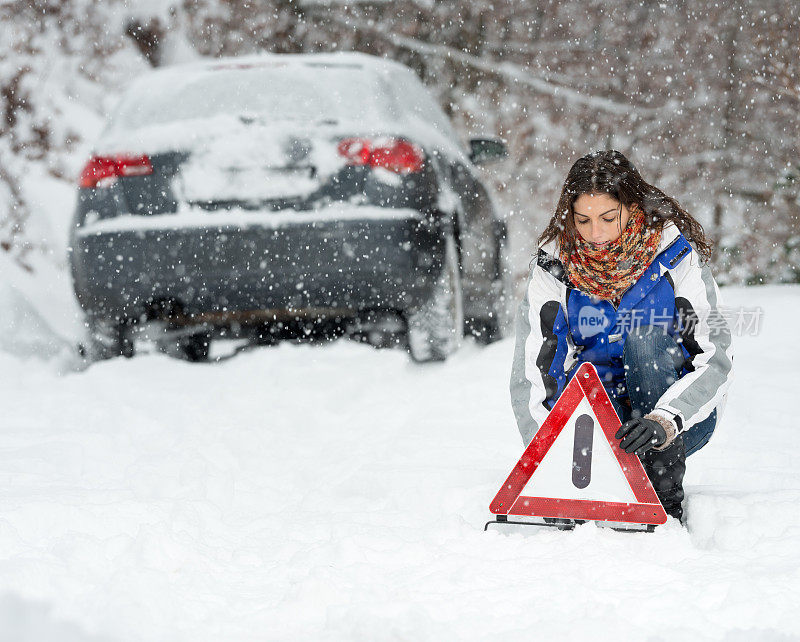 冬季汽车故障，女人警告三角，暴风雪