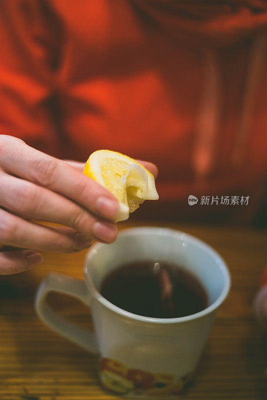 女人往茶杯里加蜂蜜的特写