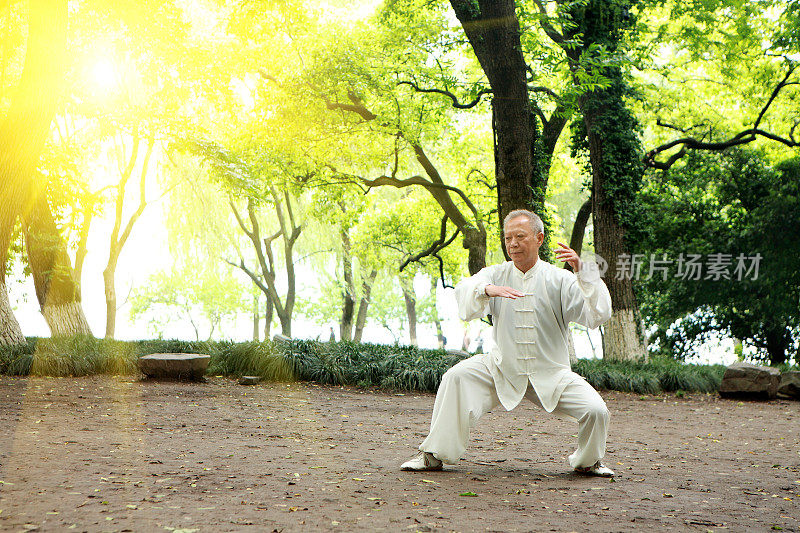 一个亚裔老人穿着白色衣服在户外运动