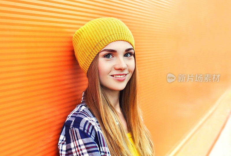 肖像特写漂亮的小女孩，头上戴着五颜六色的黄色帽子