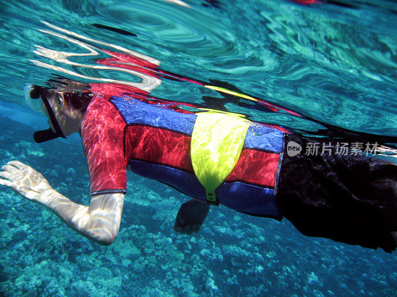 夏威夷毛伊岛，一名男子穿着潜水服在水下浮潜