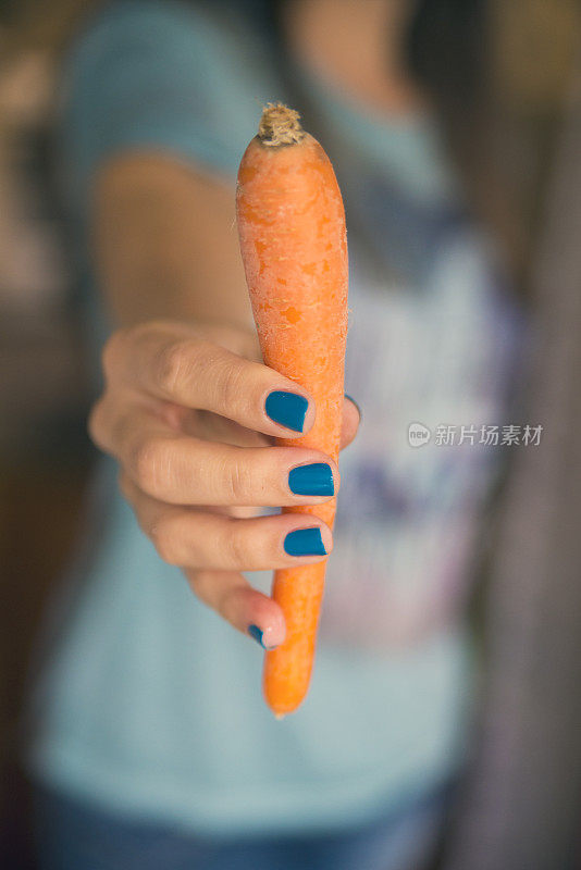 节食――年轻的家庭主妇拿着胡萝卜