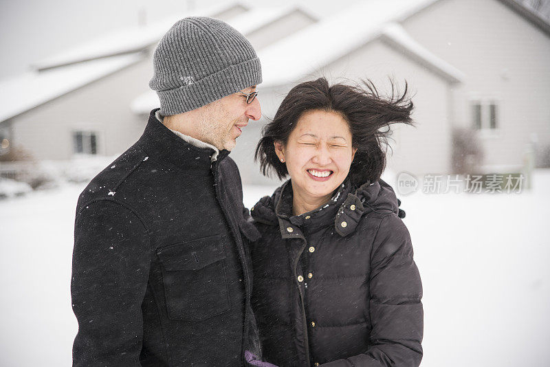 多民族的夫妇在雪下享受户外的乐趣