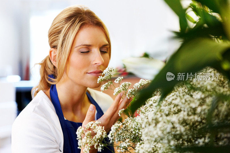 迷人的年轻女子花商闻花