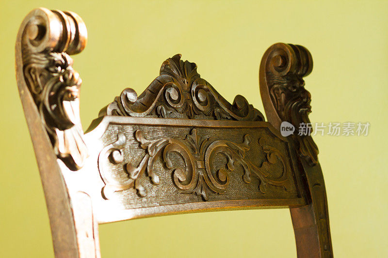 古色古香的巴洛克雕花椅，淡绿色背景(特写细节)