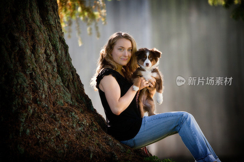 一个年轻女人和她的小狗的户外肖像。