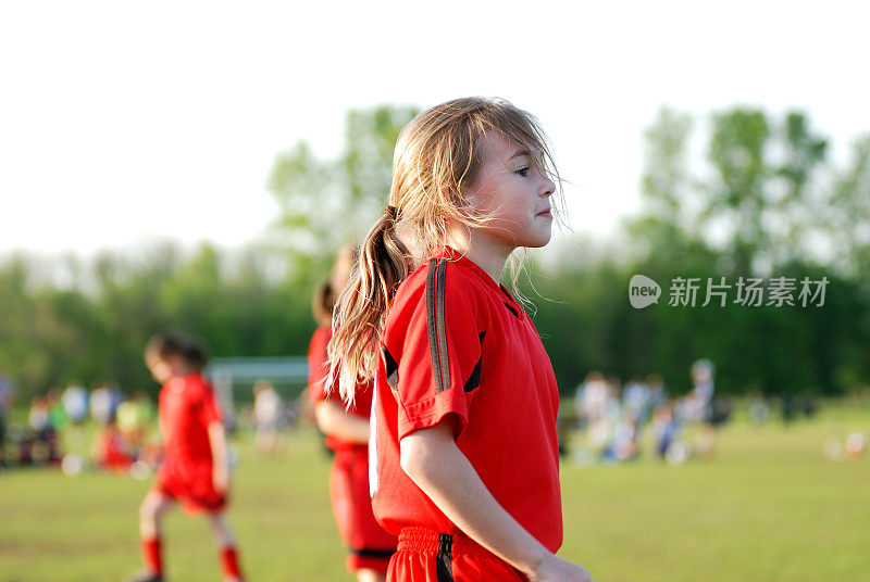 穿着足球制服的年轻女孩看着前场