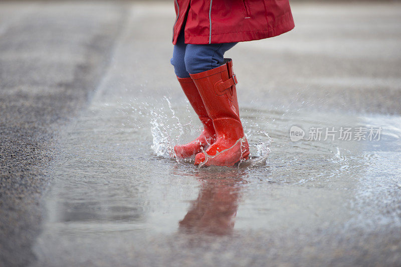 孩子们在雨天的水坑上跳。