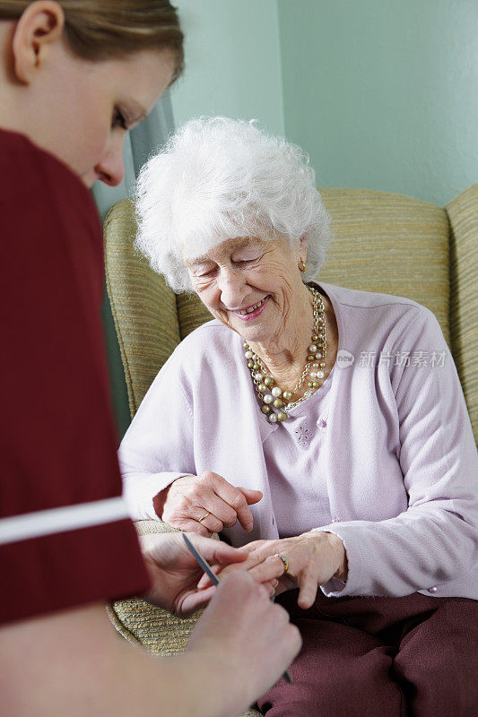 在养老院，护士整理老年妇女的指甲