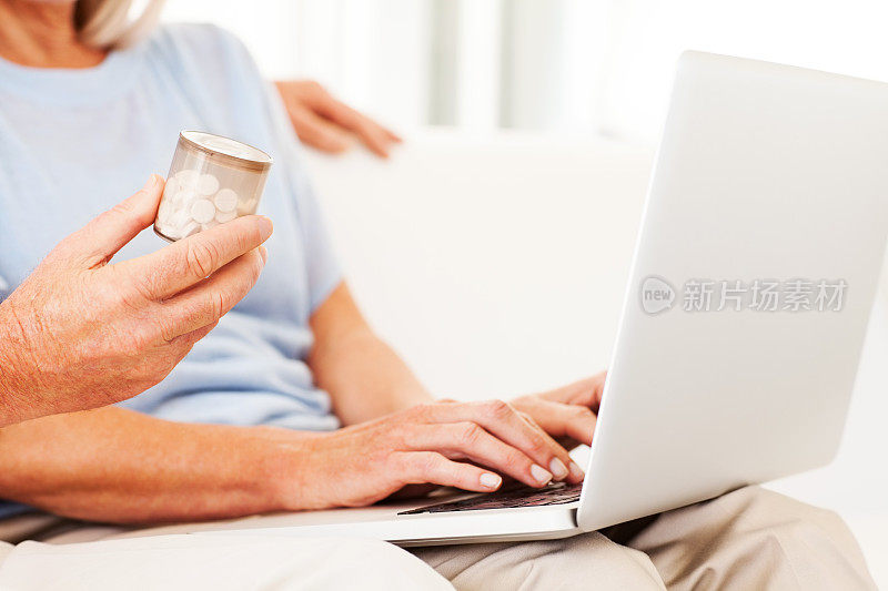 使用笔记本电脑使用药瓶的老年夫妇