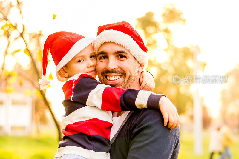 父亲和儿子戴着圣诞老人帽