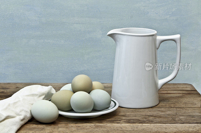 新鲜的彩色蛋来自异国品种的鸡与牛奶罐
