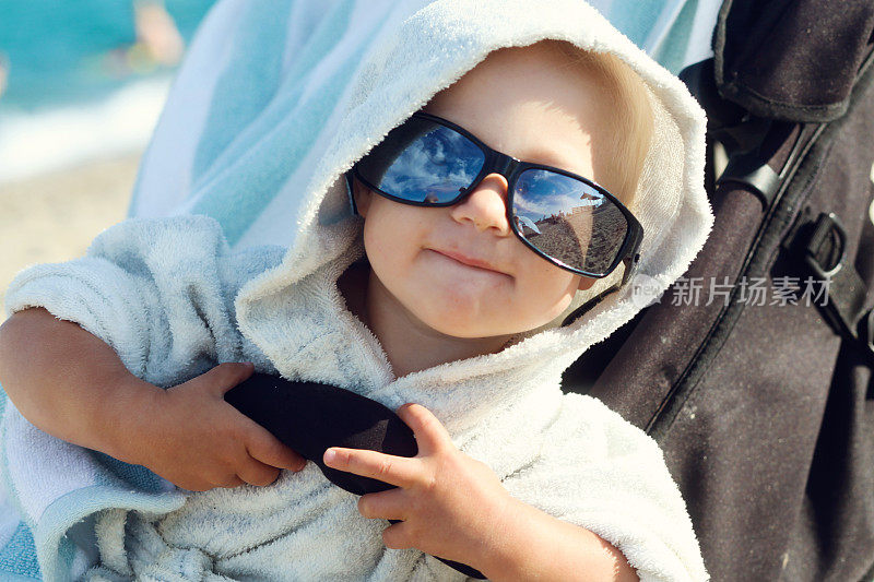 孩子戴着太阳镜在海滩上