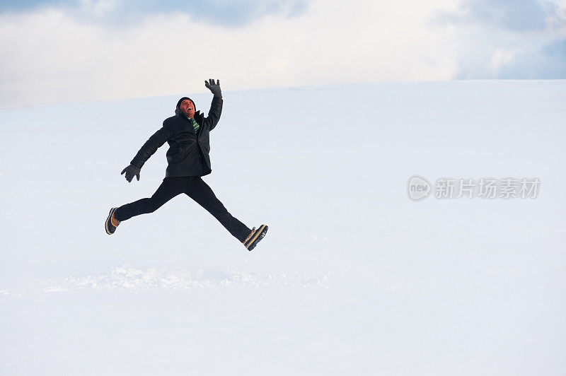 非常有活力的雄性在雪景中跳跃