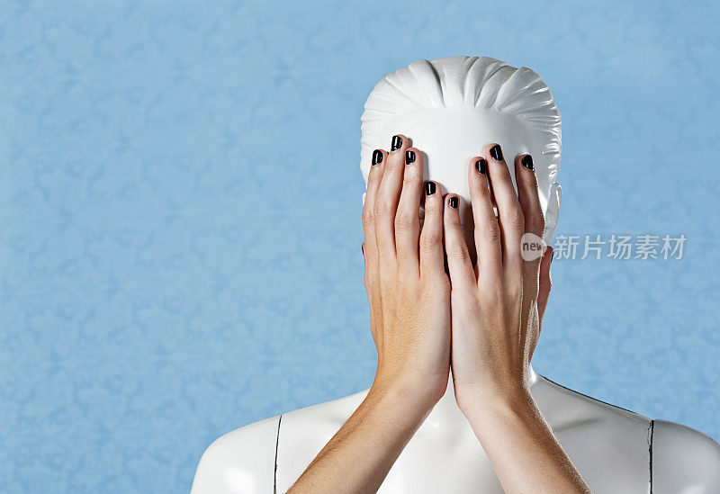 真实的，女性化的手覆盖着塑料窗户假人的脸