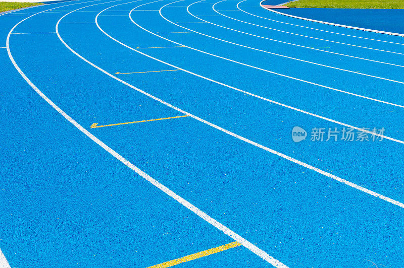 蓝色跑道。一条条蓝色跑道。户外体育场内有蓝色沥青和白色标记的跑道。有选择性的重点。