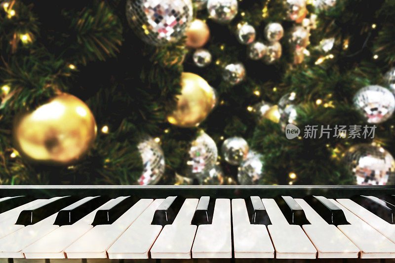 生动的金色圣诞模糊背景与钢琴键假日派对。