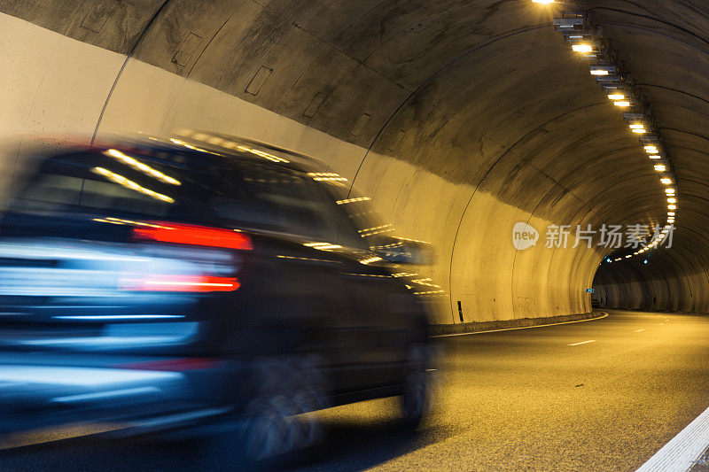 一辆黑色机动车辆穿过隧道