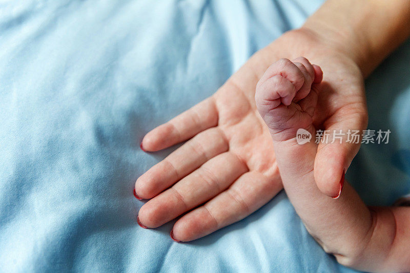 小婴儿牵着妈妈的手