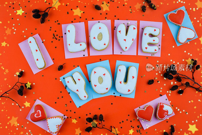 在红色背景上俯视图自制的心形饼干或情人节的“我爱你”字句
