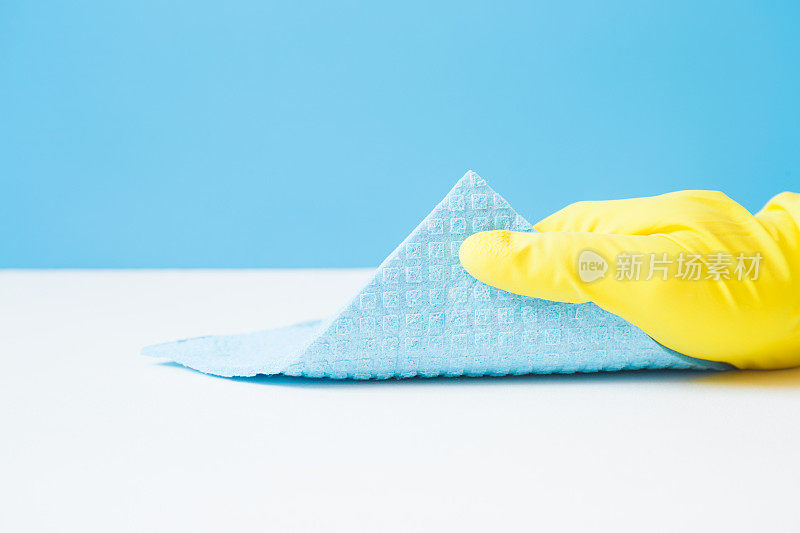 员工手戴橡胶防护手套，用蓝色海绵布擦拭房间、浴室、厨房的白色桌子或地板表面。早春或定期大扫除。商业清洁公司理念。