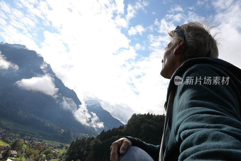 人们越过草地和村庄，望向群山