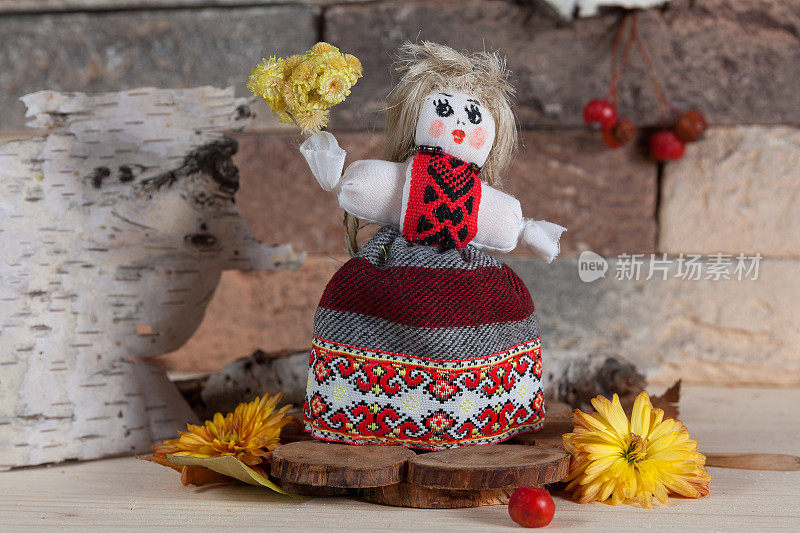 砖墙背景上的乌克兰传统motanka娃娃