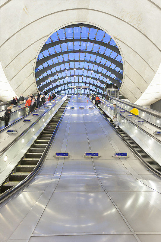伦敦金丝雀码头，乘客乘坐自动扶梯进入地铁站