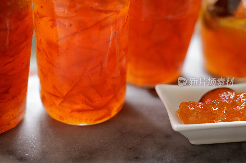 自制塞维利亚苦橙果酱系列——成品果酱装在玻璃罐中，放在大理石板上