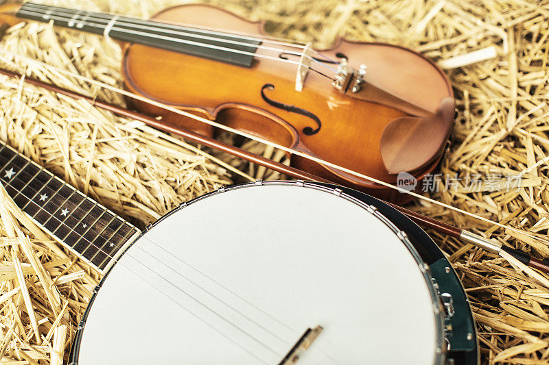 在稻草中收集的乐器，完美的乡村音乐:小提琴和班卓琴