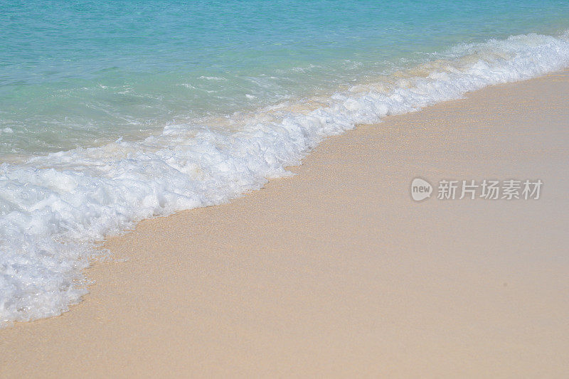 海浪和荡漾的泡沫拍打着热带海滩上的金色沙滩，这是许多人心目中的天堂。