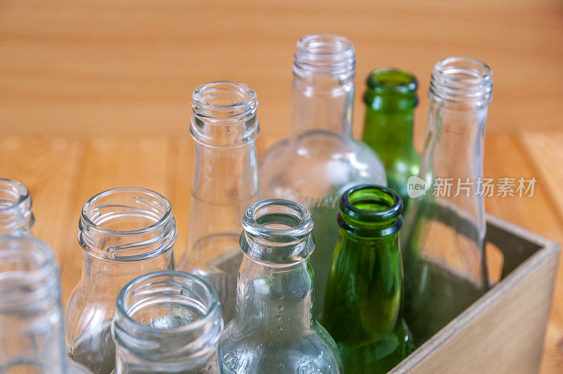 空玻璃瓶装在一个木箱里，放在木板上供回收利用