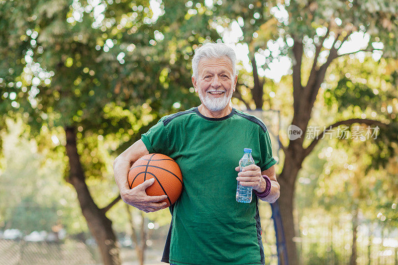 肖像活跃的老年人在篮球场上休息从体育活动