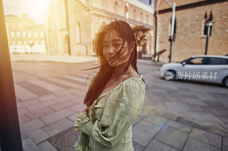 年轻女子提着手提包过马路