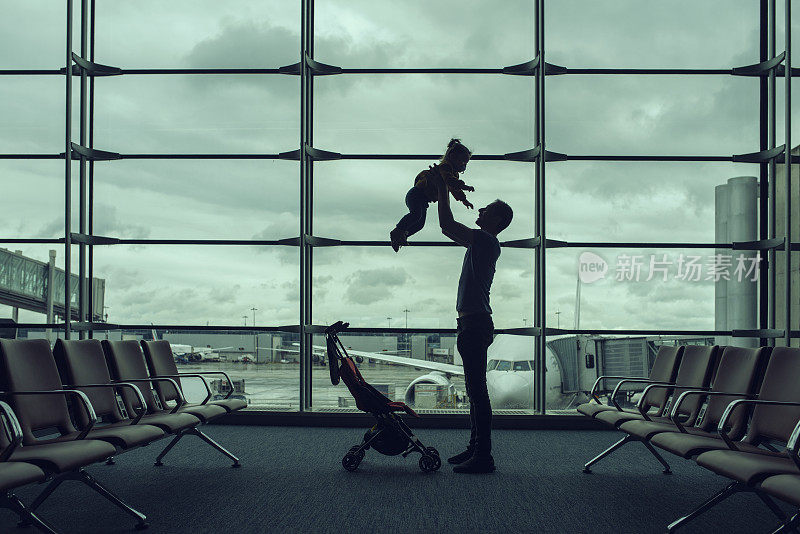 父亲带着她的小女儿在机场玩耍