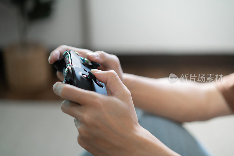 年轻的亚洲男子玩家控制器视频游戏机玩holding爱好好玩的在线视频游戏享受电子竞技网络游戏互联网。